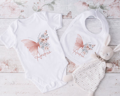 Blush butterfly personalised bib shown as part of a new baby gift set.
