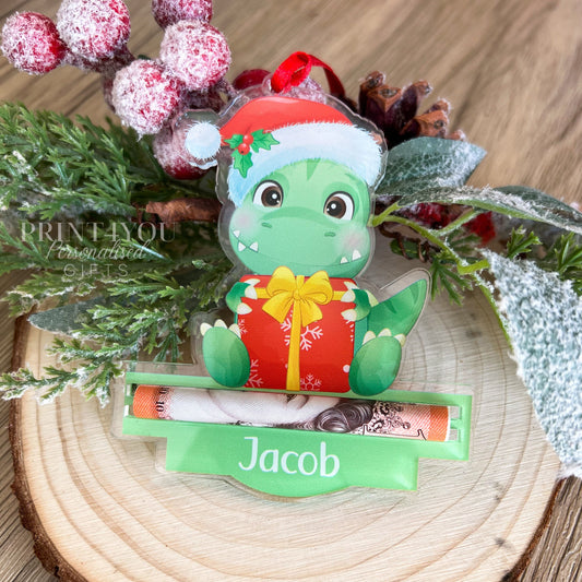 Personalised acrylic dinosaur Christmas tree decoration with a slot for holding a folded banknote, shown without gift box option