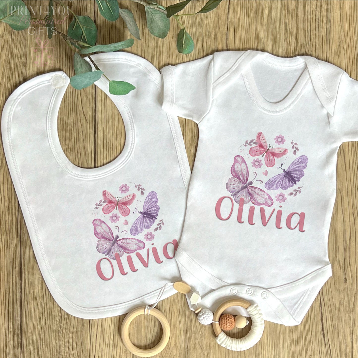 Personalised pink and purple butterfly vest for a new baby, printed with baby's name on soft white cotton.