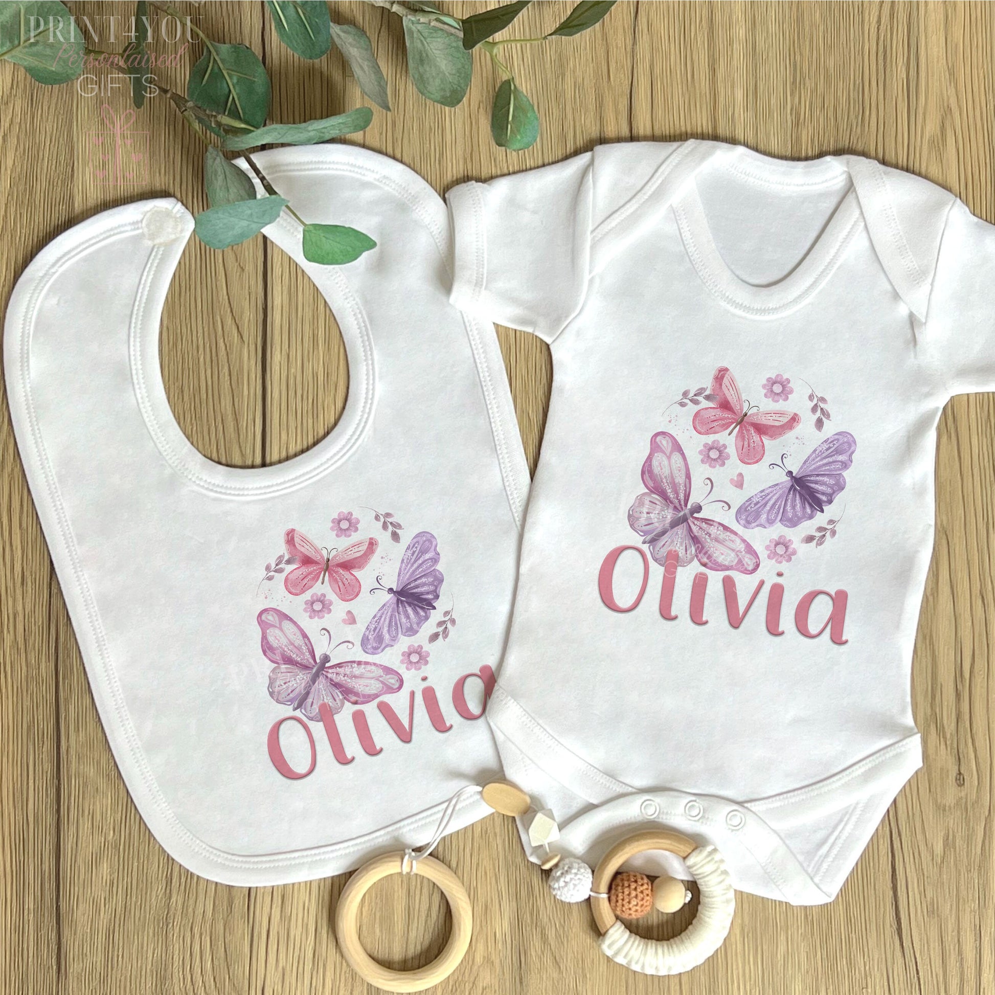 Personalised pink and purple butterfly vest for a new baby, printed with baby's name on soft white cotton.