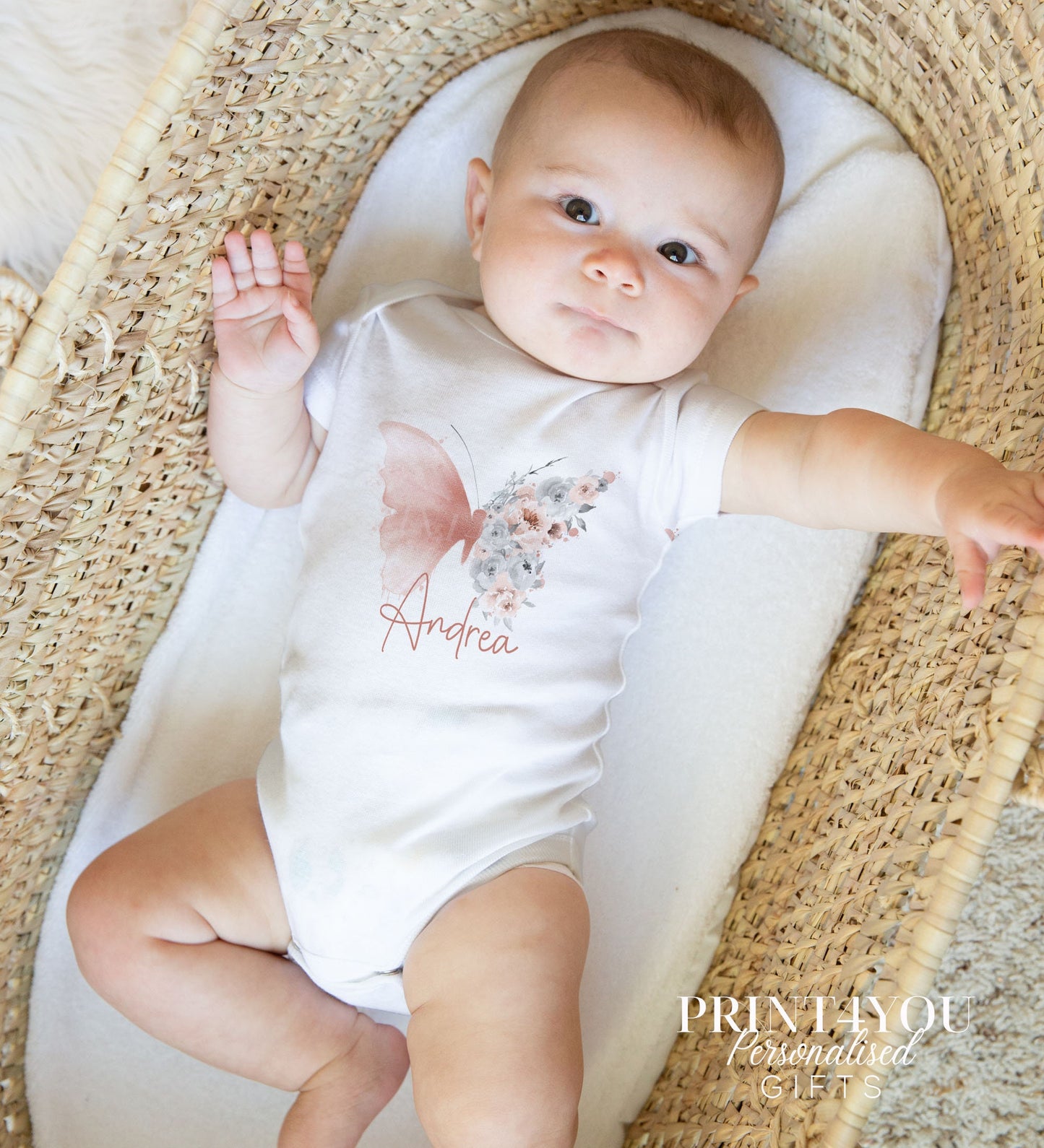 Close-up of the blush butterfly design and personalised name on the baby bib.
