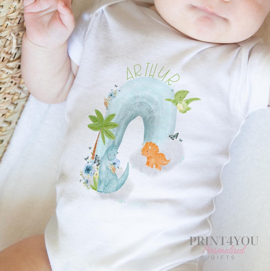Personalised vest featuring the dinosaurs on a rainbow print, in soft white cotton.