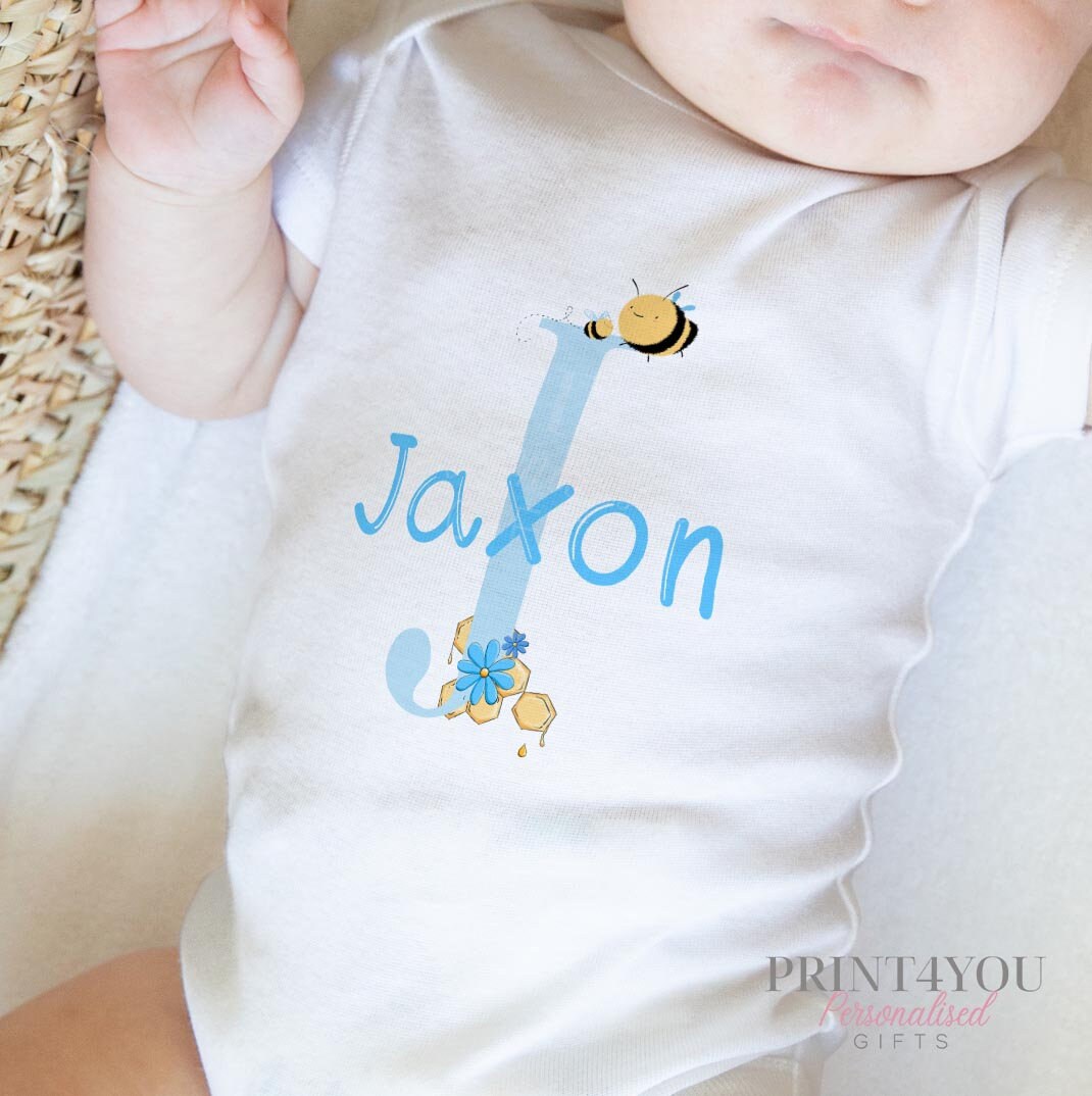 Bib in soft white cotton printed with the blue alphabet letter bumble bee design.