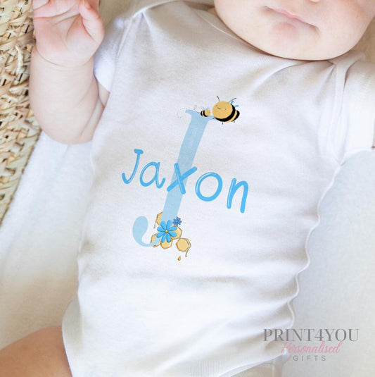 Bib in soft white cotton printed with the blue alphabet letter bumble bee design.