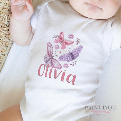 Personalised new baby bib in white cotton, printed with pink and purple butterflies and your baby's name.