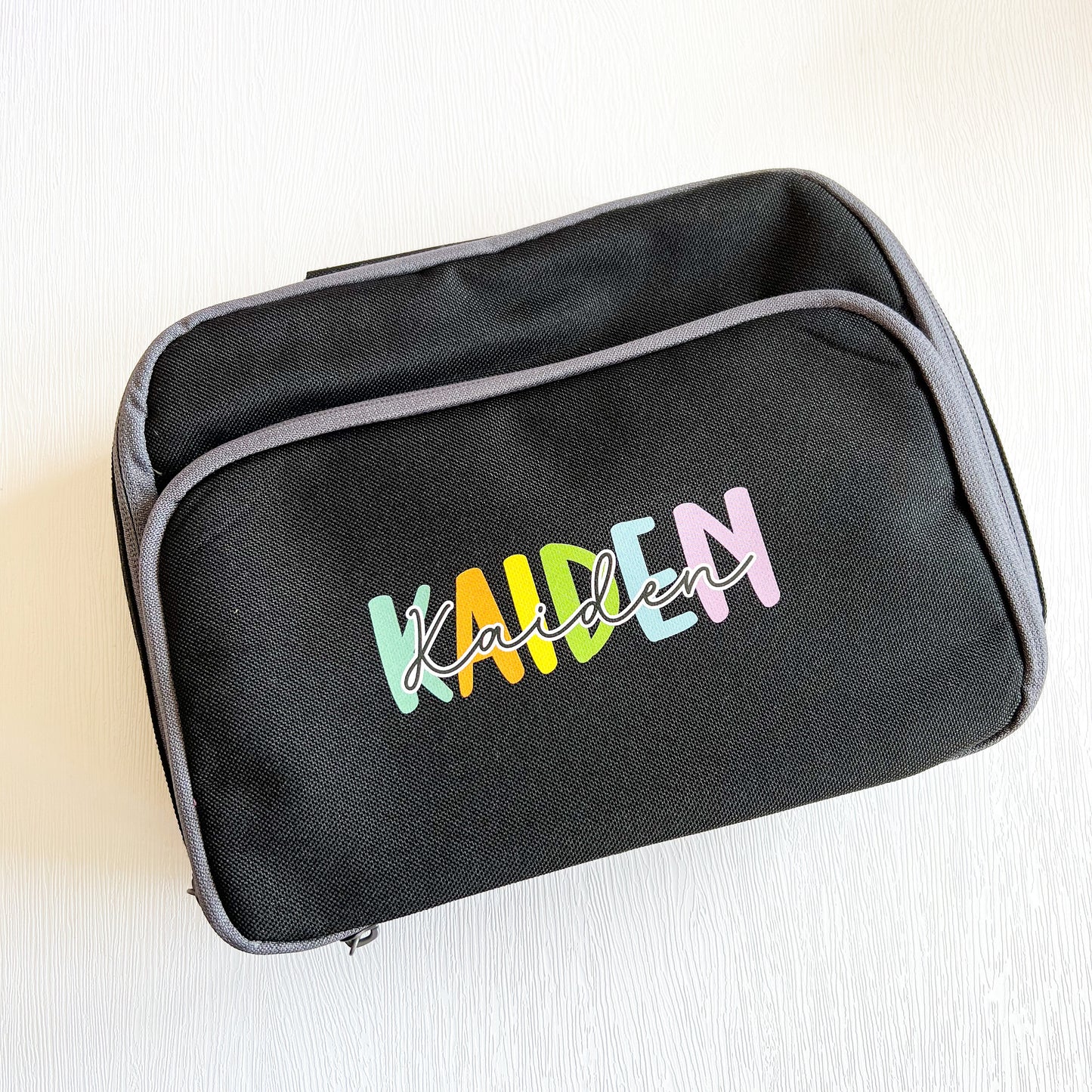 Personalised pink insulated rainbow lunch cooler bag with a name printed on the front.