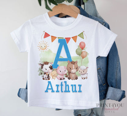 White T-shirt printed with a blue letter A, farmyard animals and the personalised name Arthur, displayed on a hanger with a denim jacket.