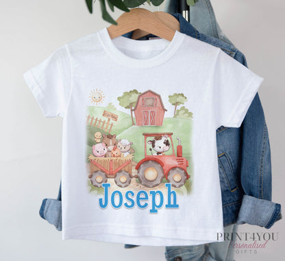 White T-shirt printed with a red tractor, farm animals and a barn, and the personalised name Joseph, displayed on a hanger.
