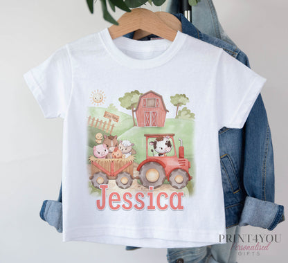 White T-shirt printed with a red tractor, farm animals and a barn, and the personalised name Jessica, displayed on a hanger.