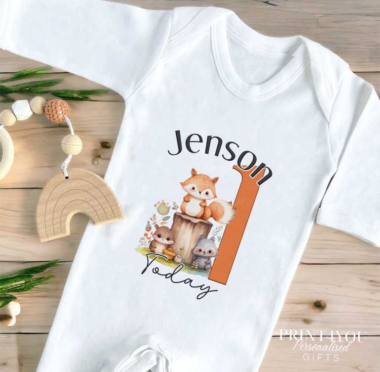White baby vest featuring the Woodland Fox first birthday print and personalised name.