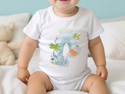 Personalised new baby bib printed with dinosaurs on a rainbow design and baby's name.