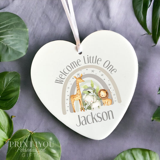 White acrylic heart-shaped hanging decoration printed with watercolour safari animals, 'Welcome Little One' and the name Jackson, shown with a hanging ribbon.
