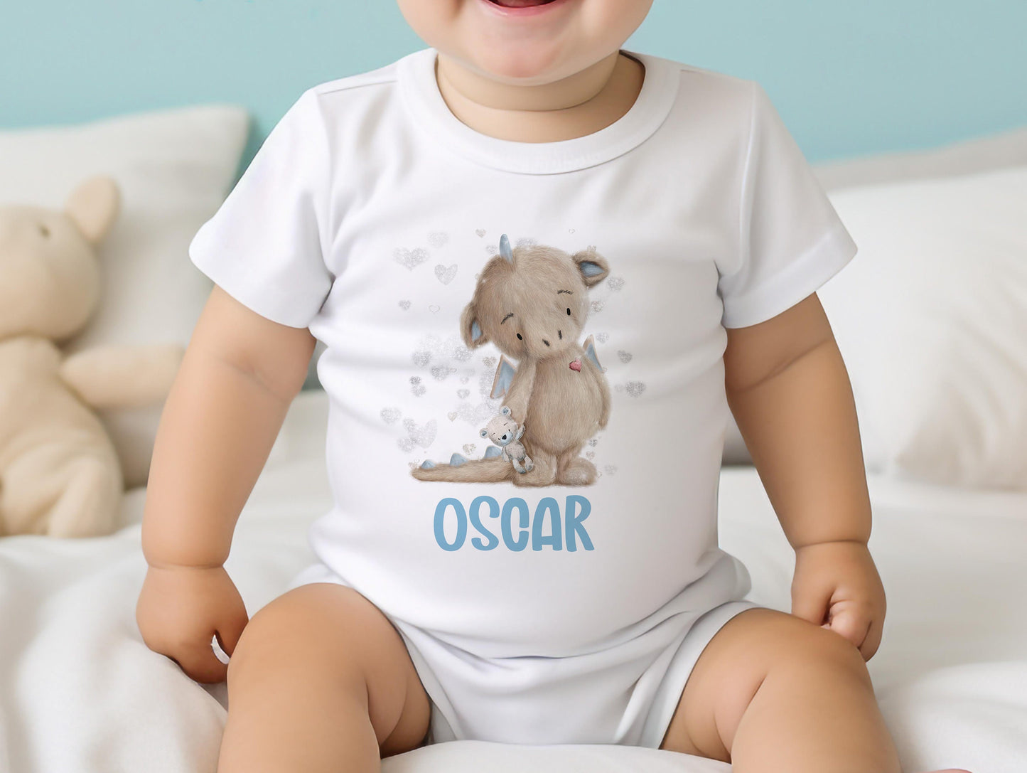 Personalised blue baby dragon bib, printed with your baby's name on soft white cotton.