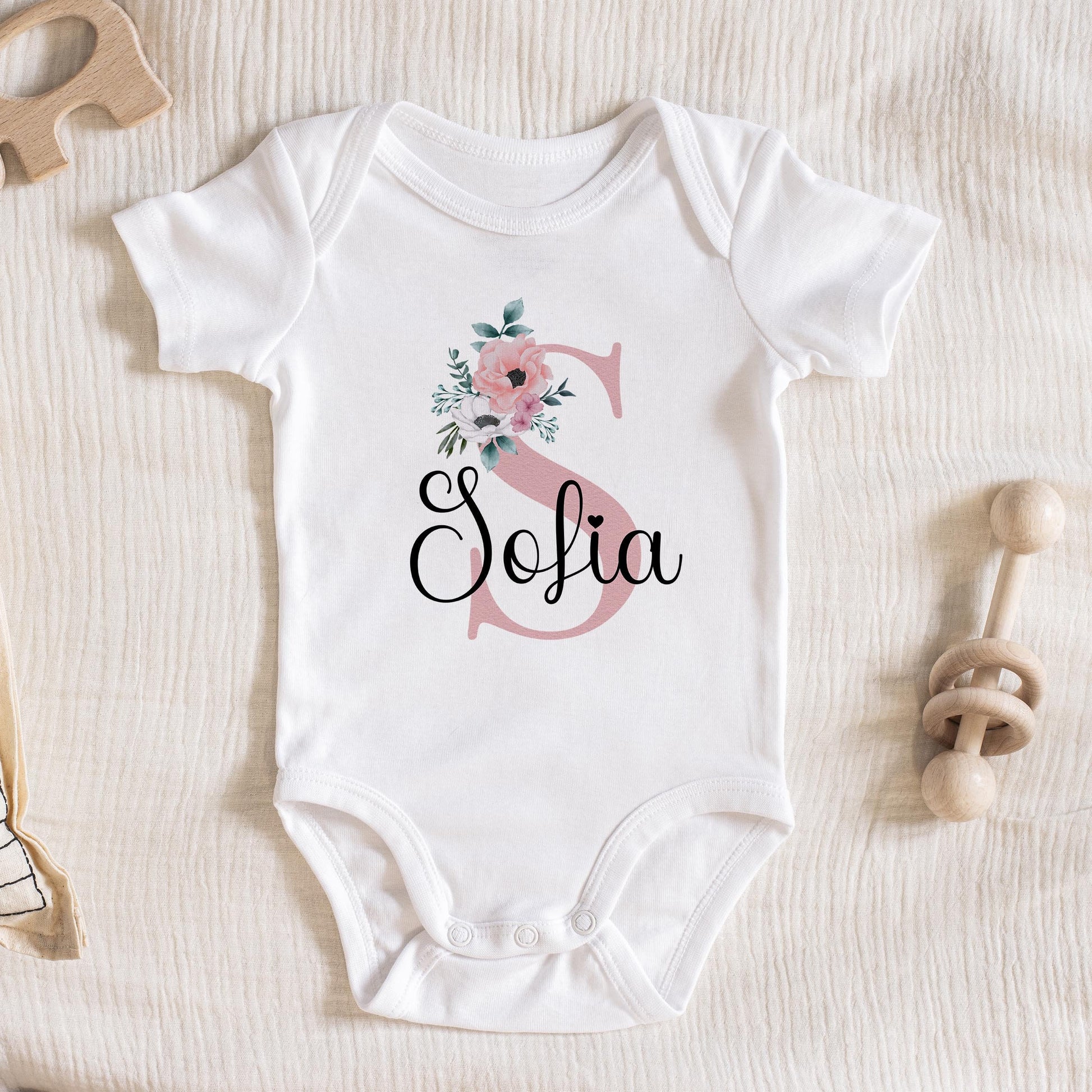 Personalised t-shirt printed with pink florals, initial letter and baby's name.