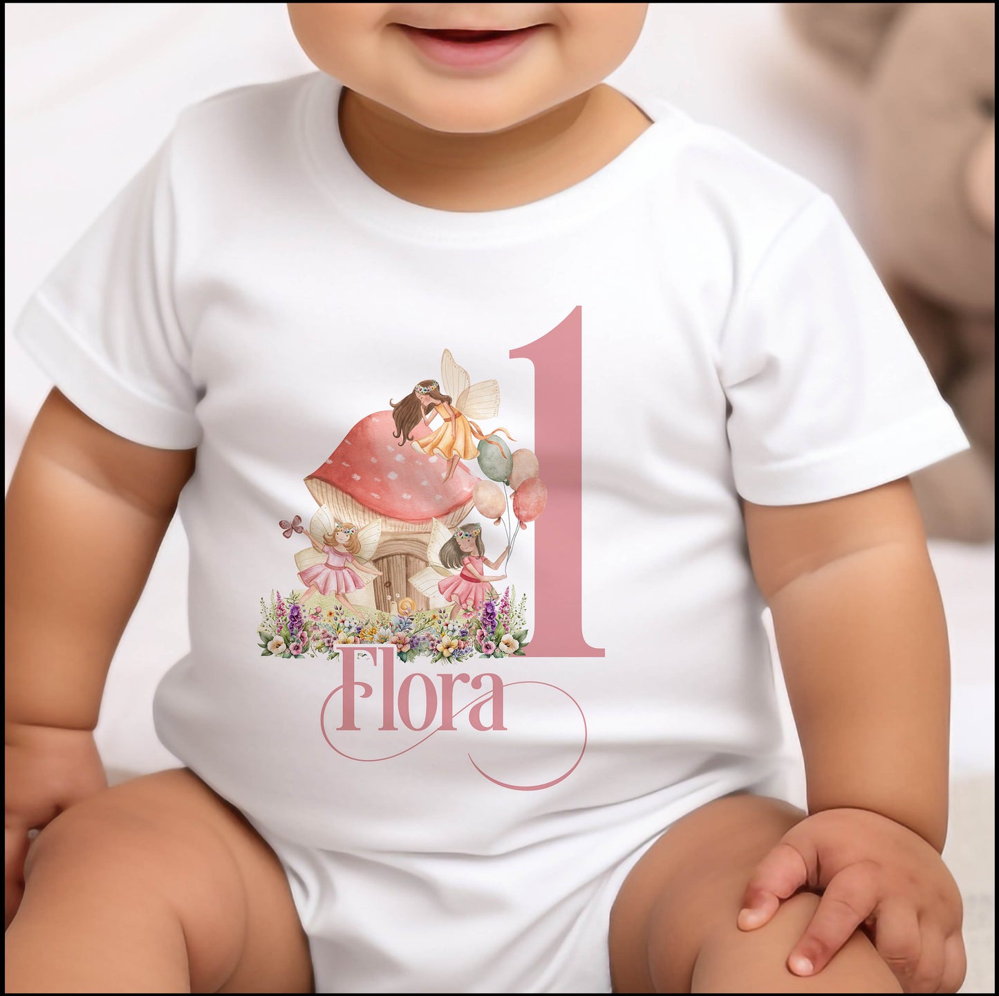 Personalised fairytale fairies first birthday bib with a bold number one and baby's name printed on soft cotton.