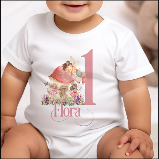 Personalised fairytale fairies first birthday bib with a bold number one and baby's name printed on soft cotton.