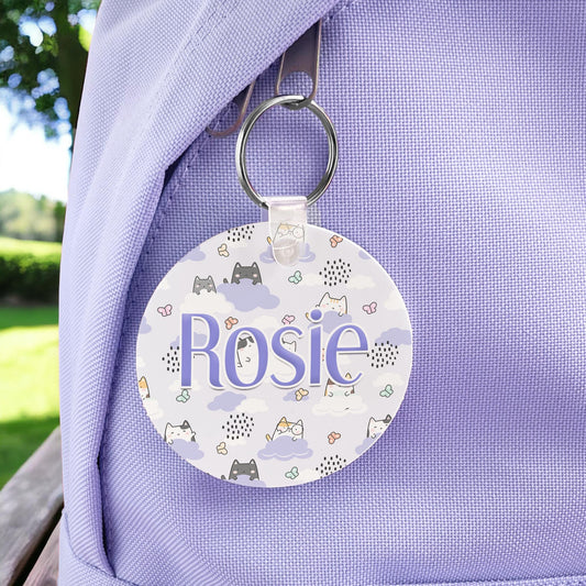 Round kawaii cats print bag tag on a keyring, personalised with the name Rosie, attached to a lilac backpack