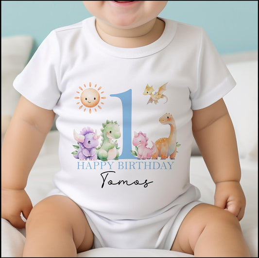 Personalised blue dinosaur first birthday bib with a bold number one and baby's name printed on soft cotton.