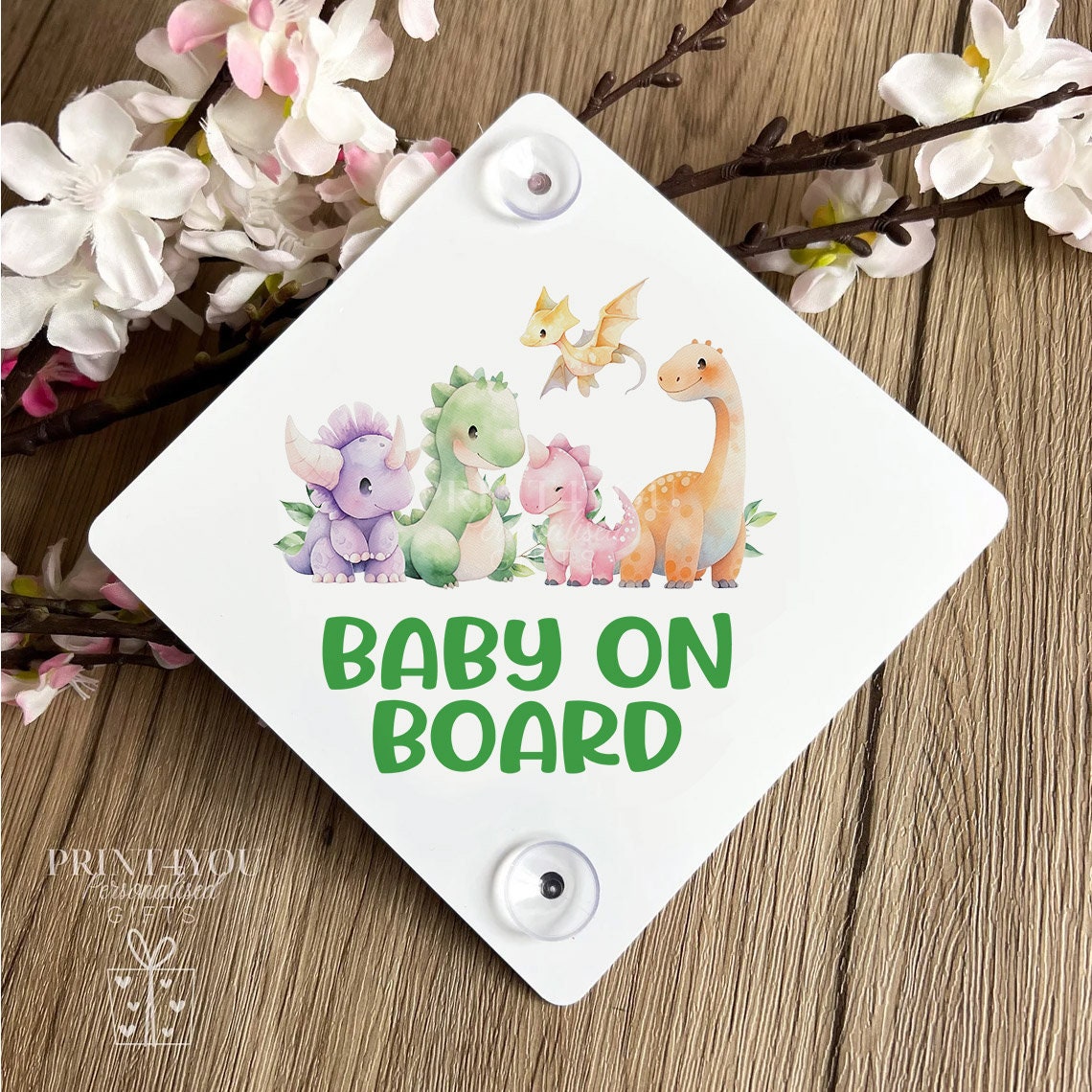 Baby on board car window sign attached with suction cups, dinosaur design