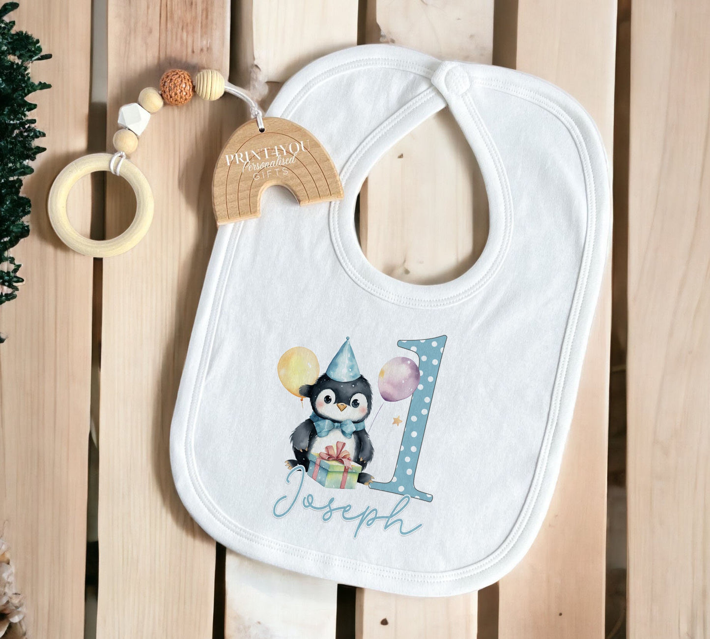 Personalised blue penguin vest printed with the baby's name for a first birthday.