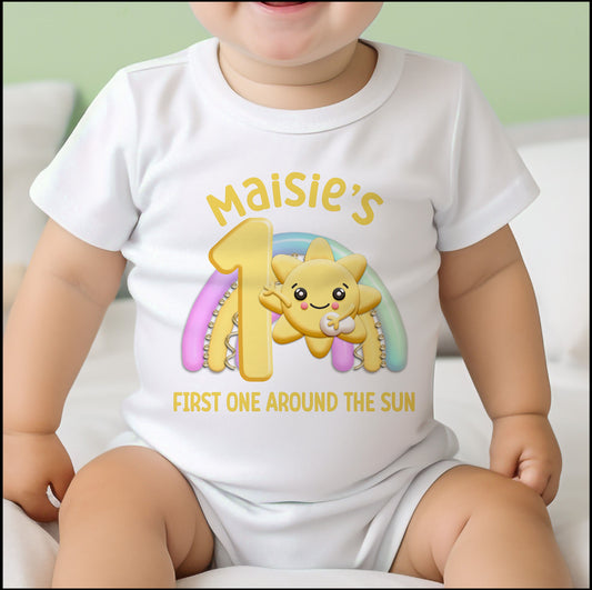 Bib in soft white cotton printed with a sunshine and rainbow design and personalised baby name.