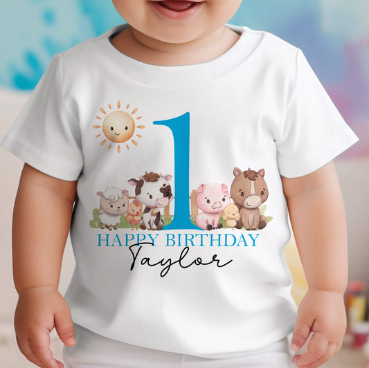 Personalised farm animals first birthday bib in soft white cotton, printed with a colourful farmyard scene and a bold blue number 1.