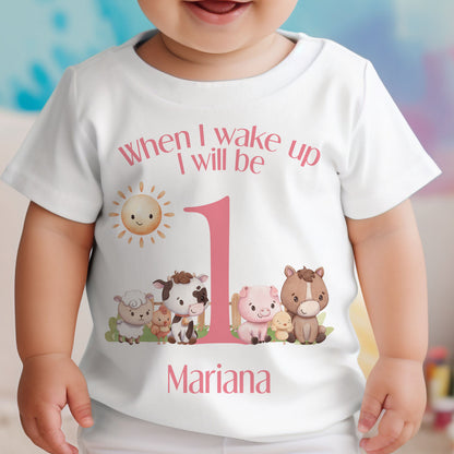 Baby wearing the personalised pink farm animals first birthday sleepsuit.