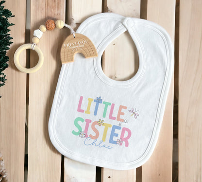Flat lay of the personalised Little Sister baby clothing gift set